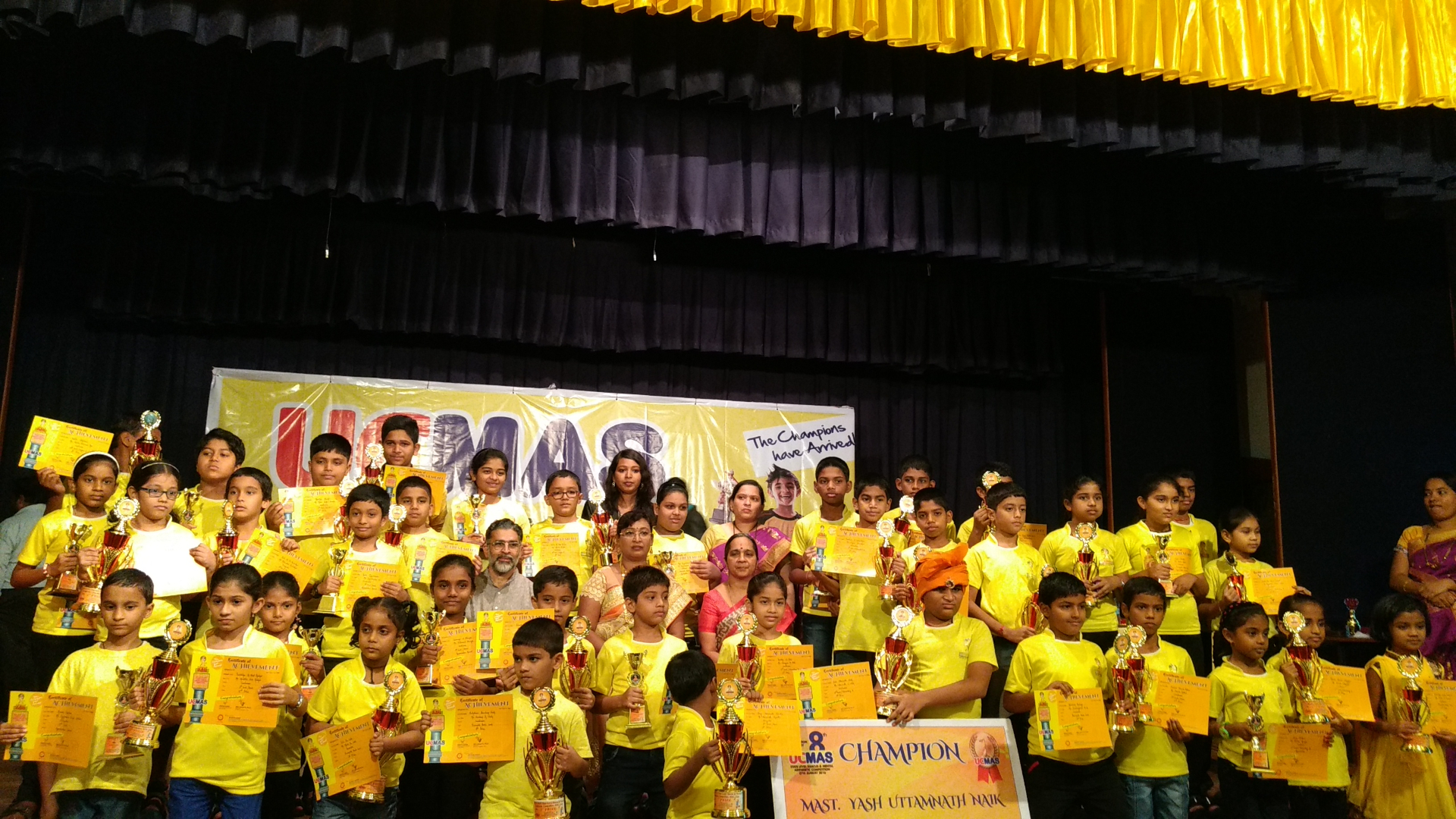 Prize winners celebrated on stage with trophies and certificates